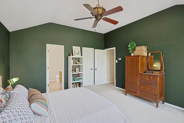 bedroom featuring ceiling fan, light colored carpet, lofted ceiling, and connected bathroom