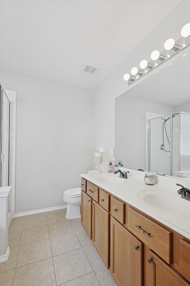 bathroom featuring tile patterned floors, toilet, a shower with door, and vanity