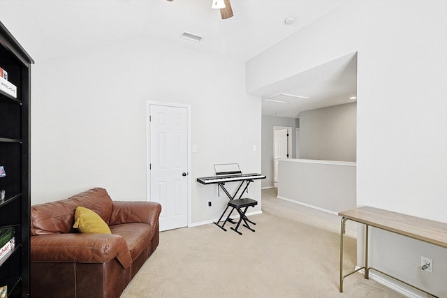 sitting room with ceiling fan, lofted ceiling, and light carpet