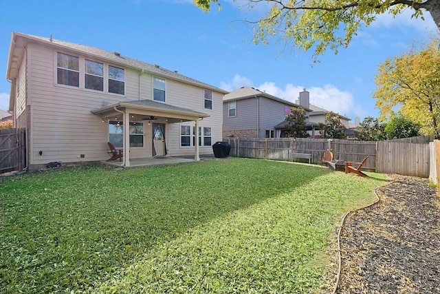 rear view of property featuring a yard and a patio area