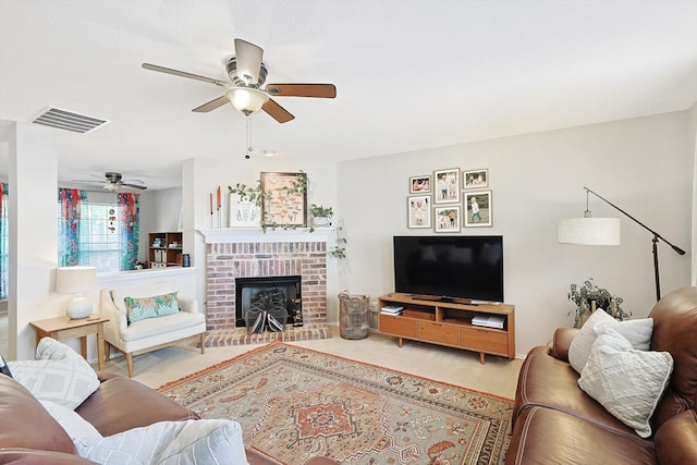 carpeted living room featuring a brick fireplace and ceiling fan