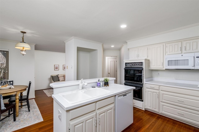 kitchen with white appliances, dark hardwood / wood-style floors, hanging light fixtures, a kitchen island with sink, and sink