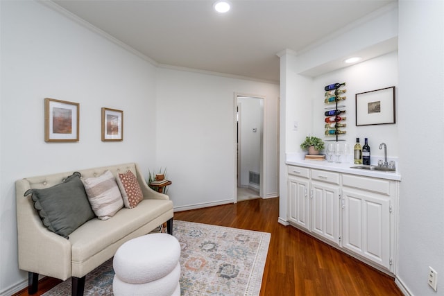 interior space with wet bar, dark hardwood / wood-style flooring, and crown molding