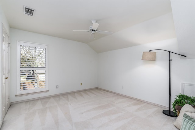 carpeted spare room featuring lofted ceiling and ceiling fan