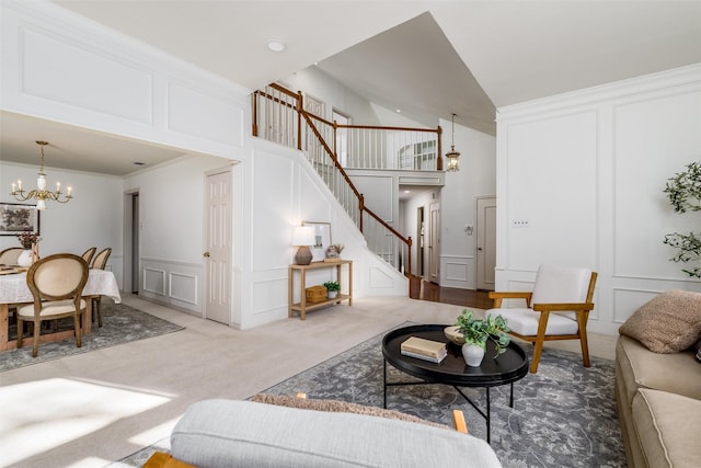 carpeted living room with high vaulted ceiling, crown molding, and a chandelier