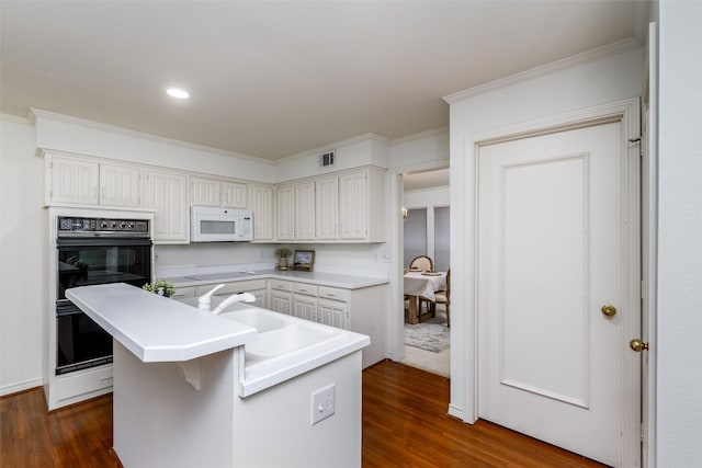 kitchen with black double oven, white cabinetry, and dark wood-type flooring