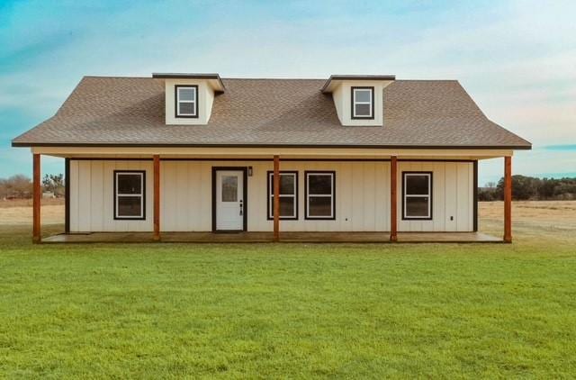 back of house featuring a lawn and covered porch