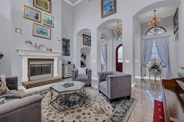 living room featuring a notable chandelier, a towering ceiling, and ornamental molding