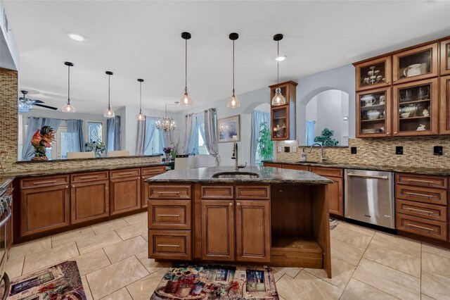 kitchen with sink, an island with sink, appliances with stainless steel finishes, decorative light fixtures, and kitchen peninsula