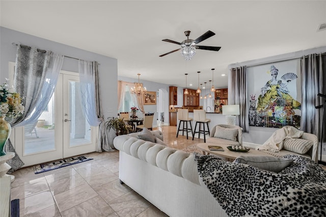 living room with french doors and ceiling fan with notable chandelier