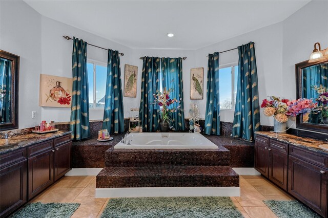 bathroom featuring tile patterned floors, vanity, and tiled bath