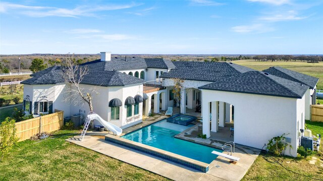 rear view of property featuring a lawn, a fenced in pool, and a patio