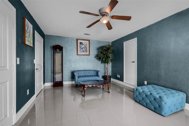 living area featuring ceiling fan and light tile patterned floors