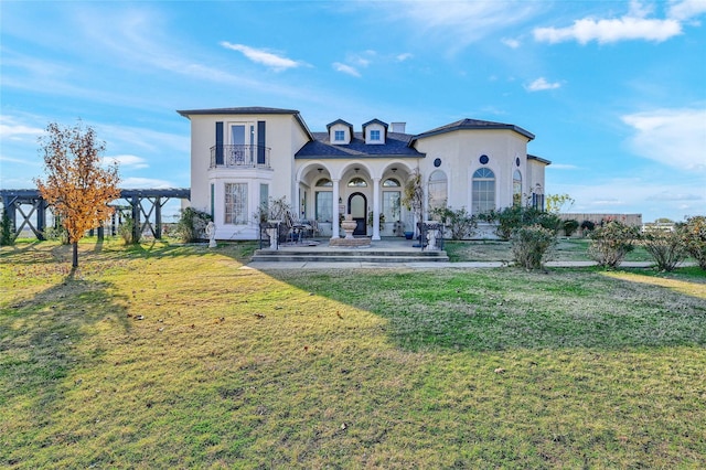 view of front facade featuring a balcony, a pergola, and a front yard