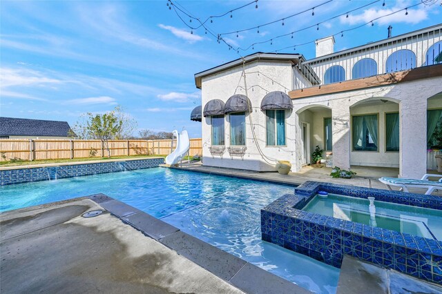 view of pool with an in ground hot tub and a water slide