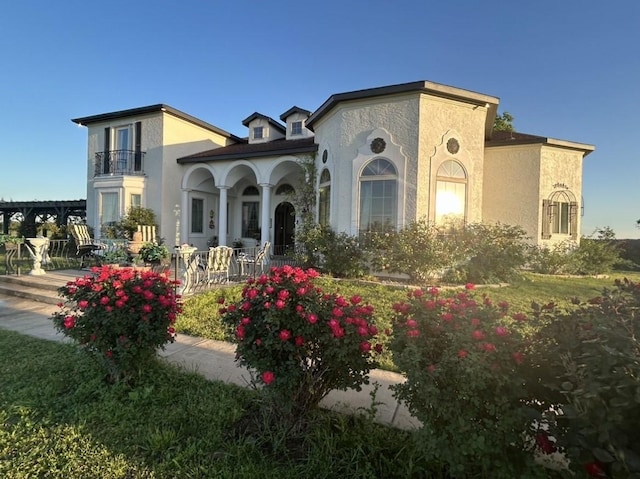 mediterranean / spanish home with covered porch and a balcony