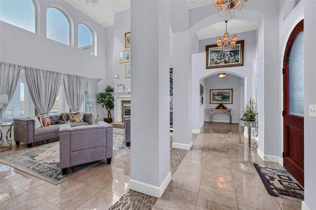 foyer entrance with a high ceiling, a notable chandelier, and light tile patterned flooring