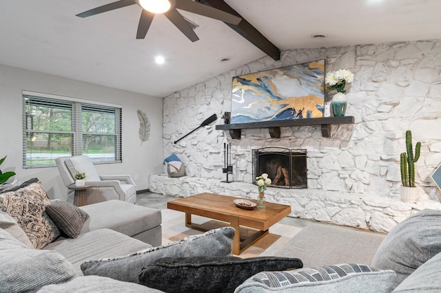 living room with lofted ceiling with beams, ceiling fan, a stone fireplace, and wood-type flooring