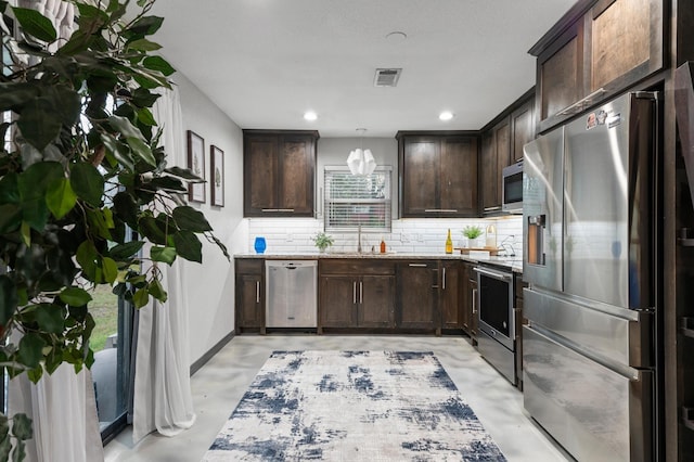 kitchen with tasteful backsplash, dark brown cabinetry, stainless steel appliances, sink, and hanging light fixtures