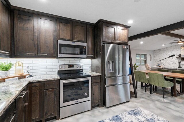 kitchen featuring light stone countertops, appliances with stainless steel finishes, tasteful backsplash, and sink