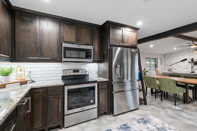 kitchen with ceiling fan, light stone countertops, dark brown cabinetry, and appliances with stainless steel finishes