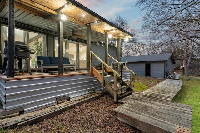 deck at dusk featuring a storage shed