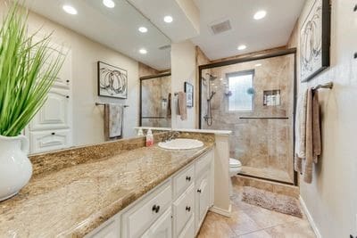 bathroom with vanity, toilet, and a shower with door