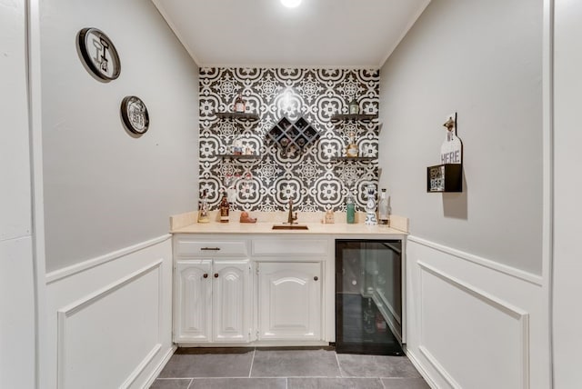 bar with wine cooler, sink, crown molding, and white cabinets