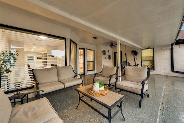 living room with ceiling fan and brick wall