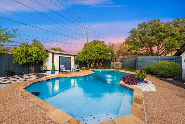 pool at dusk with an outbuilding and a patio area