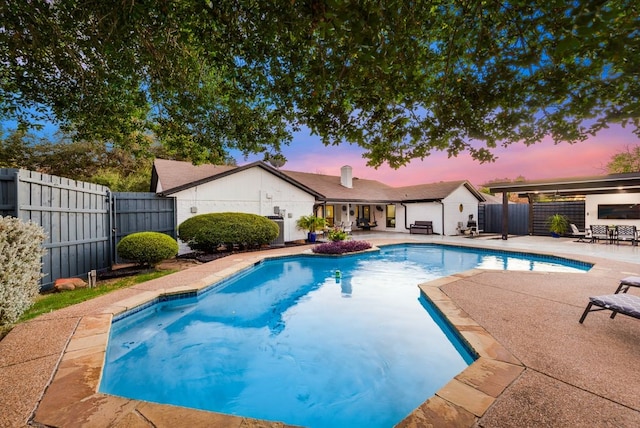 pool at dusk with a patio