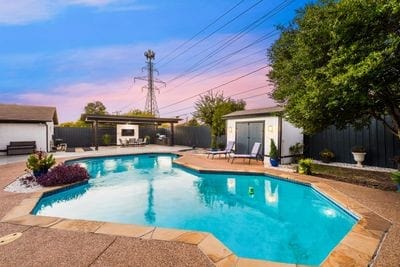 pool at dusk with a patio and a storage shed