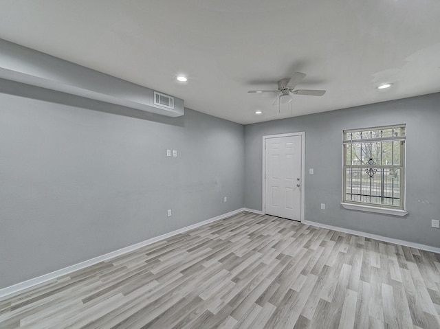 empty room with ceiling fan and light hardwood / wood-style flooring