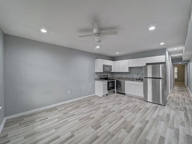 kitchen with appliances with stainless steel finishes, ceiling fan, sink, light hardwood / wood-style flooring, and white cabinetry