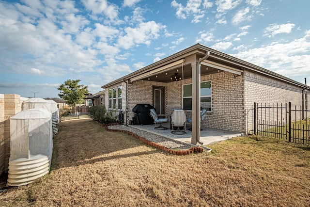 back of house featuring a lawn, a patio area, and ceiling fan