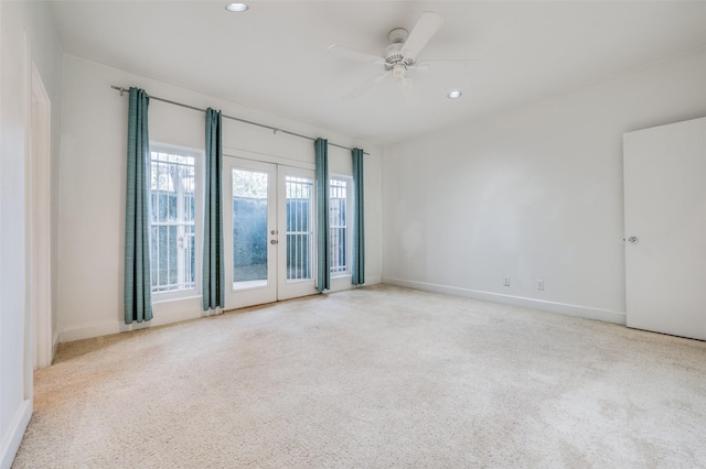 spare room featuring light carpet, french doors, and ceiling fan