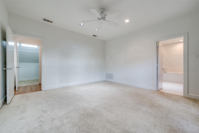 unfurnished bedroom featuring light carpet, ensuite bath, and ceiling fan