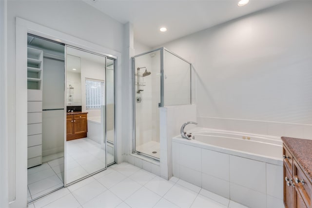 bathroom with tile patterned floors, plus walk in shower, and vanity