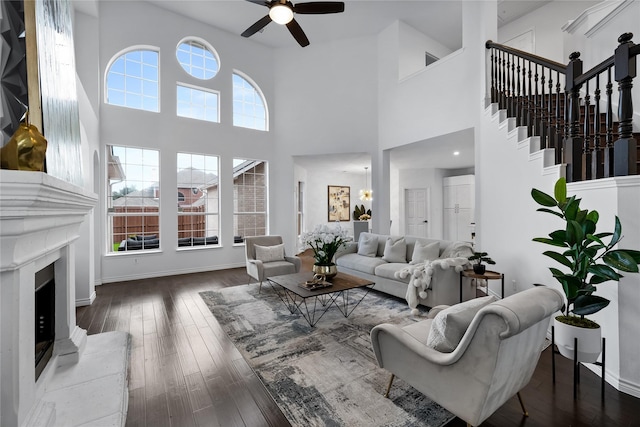 living room featuring a towering ceiling, hardwood / wood-style flooring, and ceiling fan