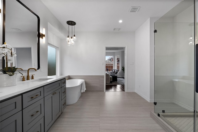 bathroom with hardwood / wood-style floors, vanity, and shower with separate bathtub