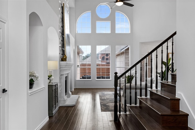 foyer featuring ceiling fan, plenty of natural light, dark hardwood / wood-style floors, and a high ceiling