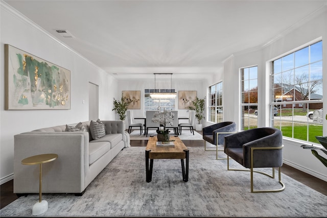 living room with a chandelier, ornamental molding, and hardwood / wood-style flooring