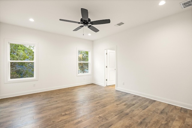 spare room featuring plenty of natural light, dark wood-type flooring, and ceiling fan