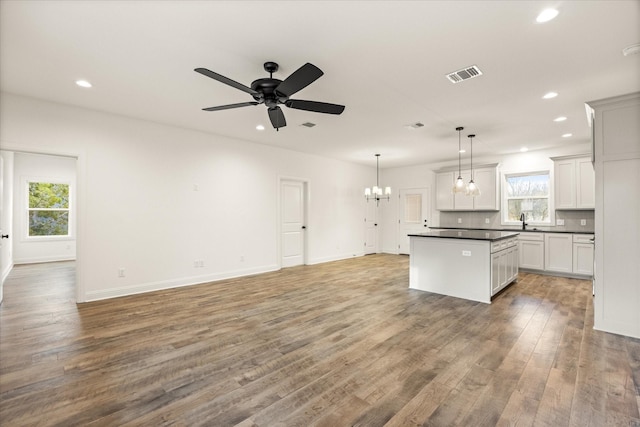 kitchen featuring pendant lighting, hardwood / wood-style floors, white cabinetry, and a healthy amount of sunlight