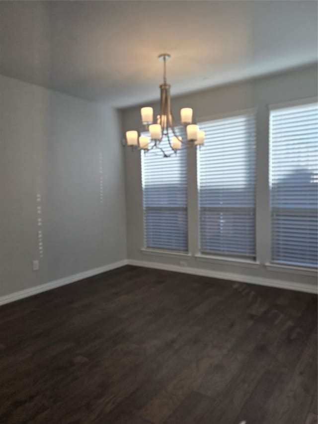 unfurnished dining area featuring an inviting chandelier and dark hardwood / wood-style floors