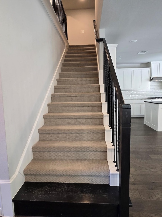 staircase with hardwood / wood-style flooring