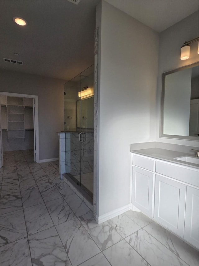 bathroom with a shower with door and vanity