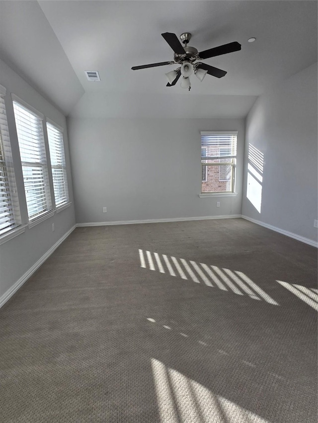 unfurnished room with ceiling fan and dark carpet