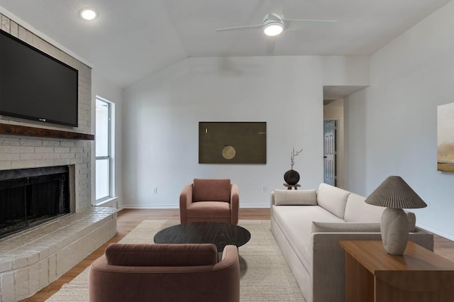 living room featuring ceiling fan, vaulted ceiling, and light hardwood / wood-style flooring