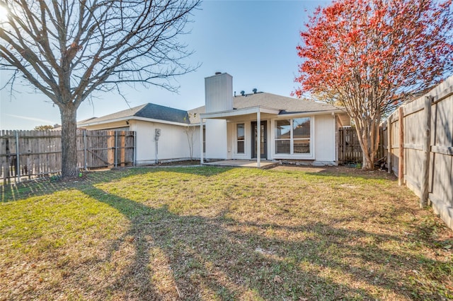 back of property featuring a lawn